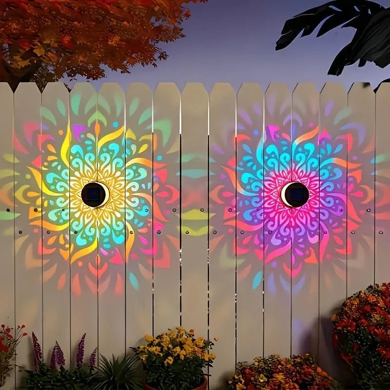 Two colorful mandala projections on garden fence